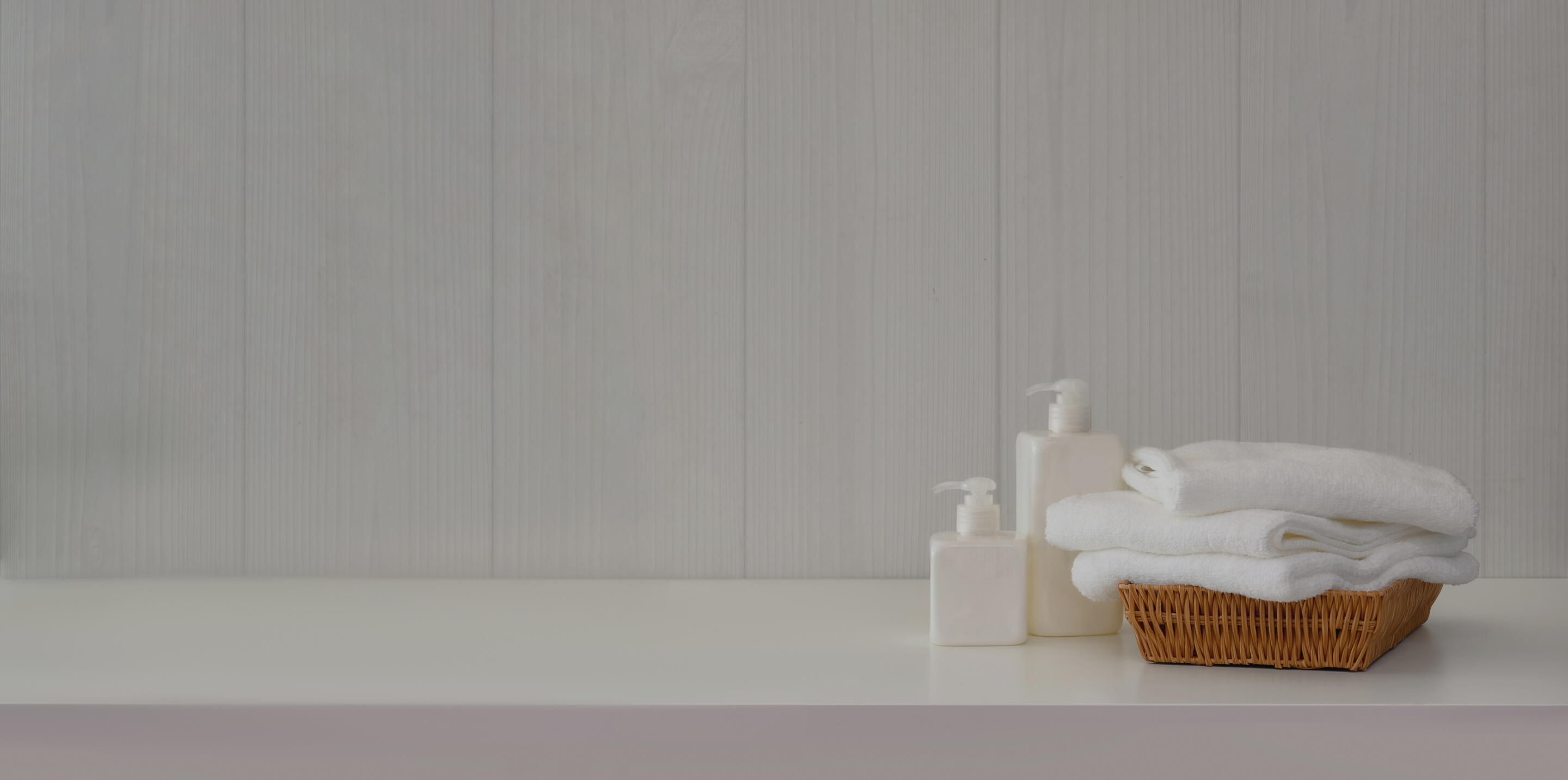 Bathroom interior with soap dispensers and towels on white table